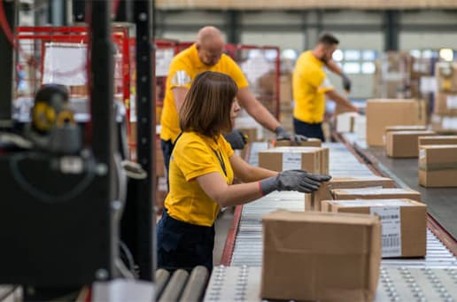 male and female worker packing courier box in warehouse